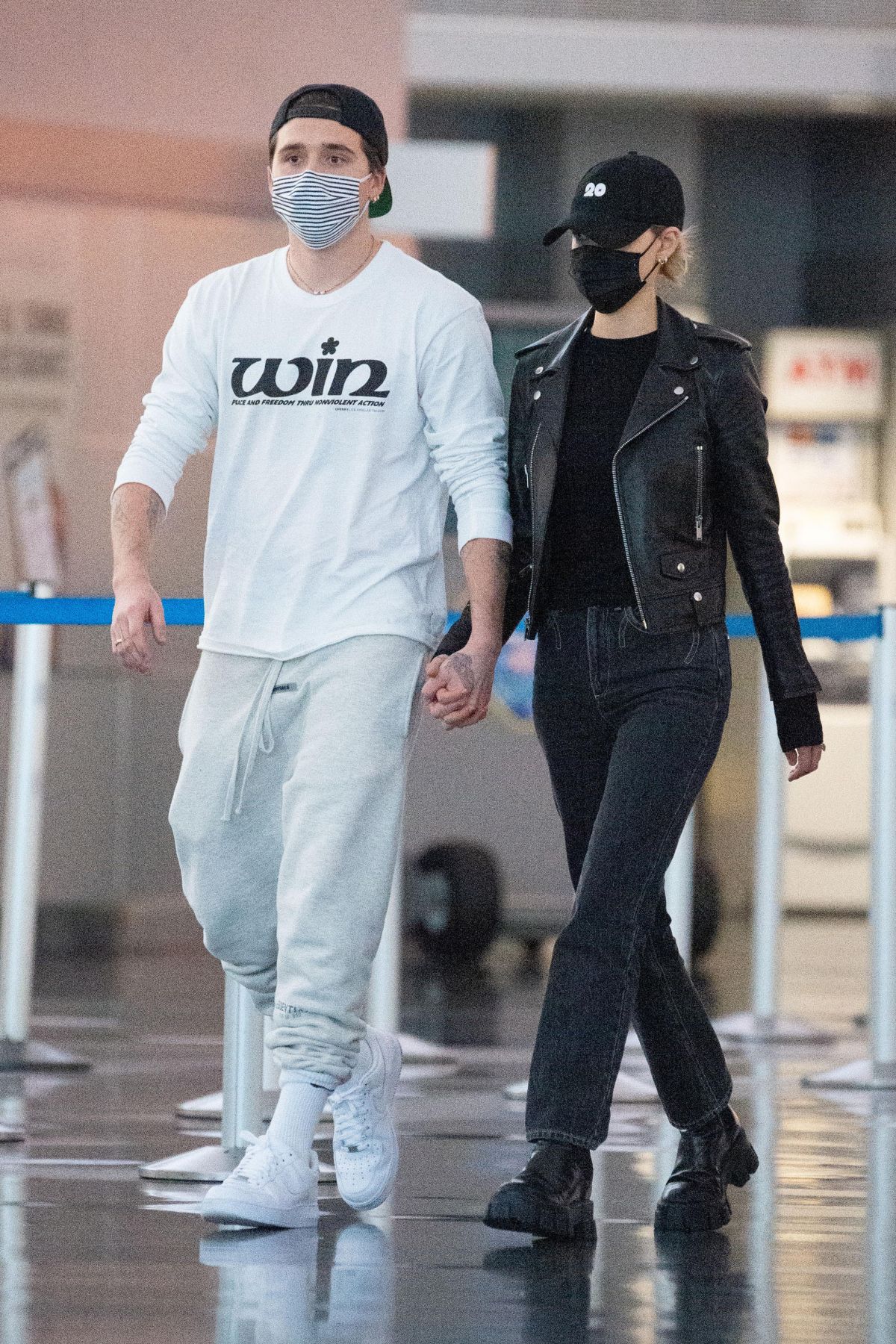 Brooklyn Beckham and Nicola Peltz don face masks and gloves as they arrive  at New York's JFK Airport